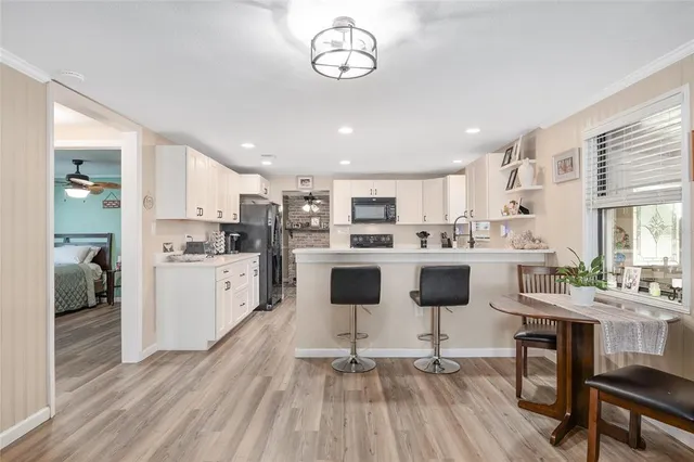 a kitchen with refrigerator a sink and chairs