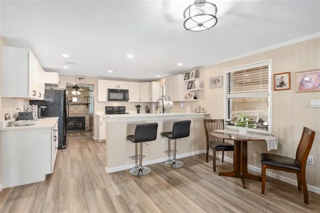 a kitchen with stainless steel appliances granite countertop a refrigerator sink and white cabinets