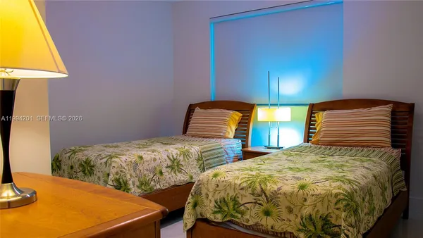 a bedroom with two beds and lamp