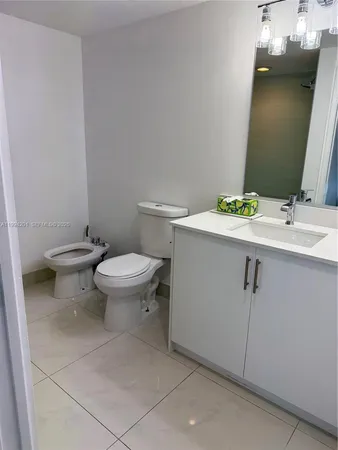 a white toilet sitting next to a bathroom sink