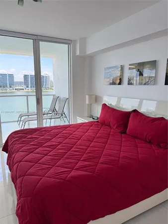 a large bed sitting in a bedroom next to a large window