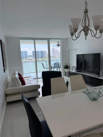 a living room with furniture a flat screen tv and a window