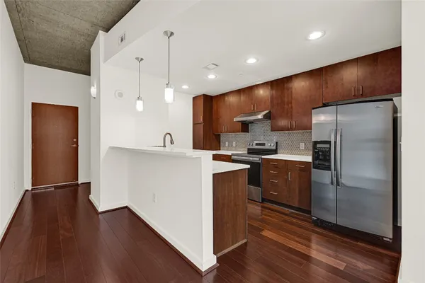 a kitchen with stainless steel appliances a refrigerator sink and microwave
