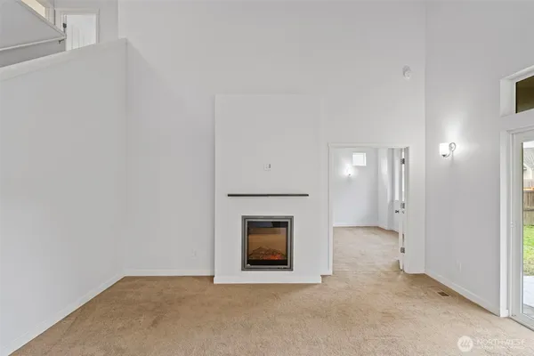 a view of an empty room with a fireplace and a window