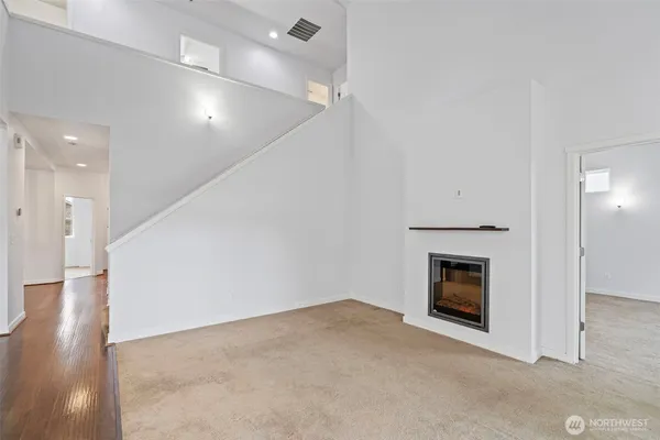 an empty room with wooden floor and a fireplace
