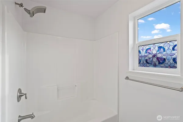 a view of an empty room and a chandelier fan