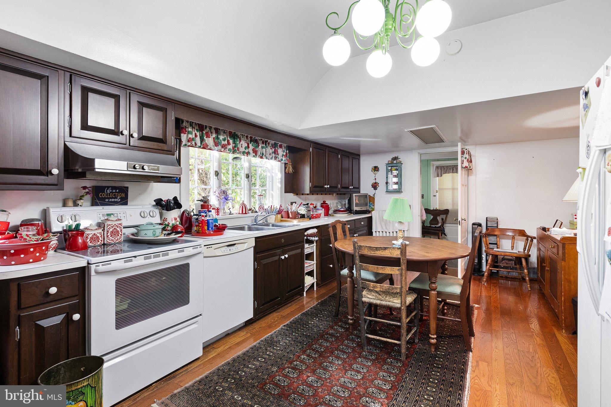 692 Bayview Road Middletown, DE 19709 - Photo 21 of 37 a kitchen with a dining table chairs and white cabinets