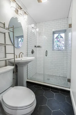 a bathroom with a sink a toilet and shower