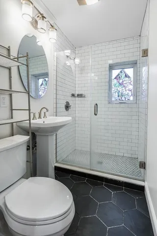 a bathroom with a sink a toilet and shower