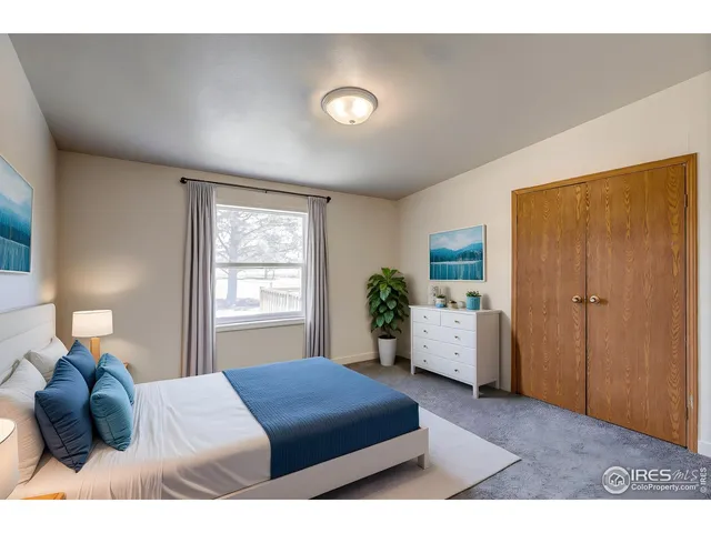 a bedroom with a bed and a large window