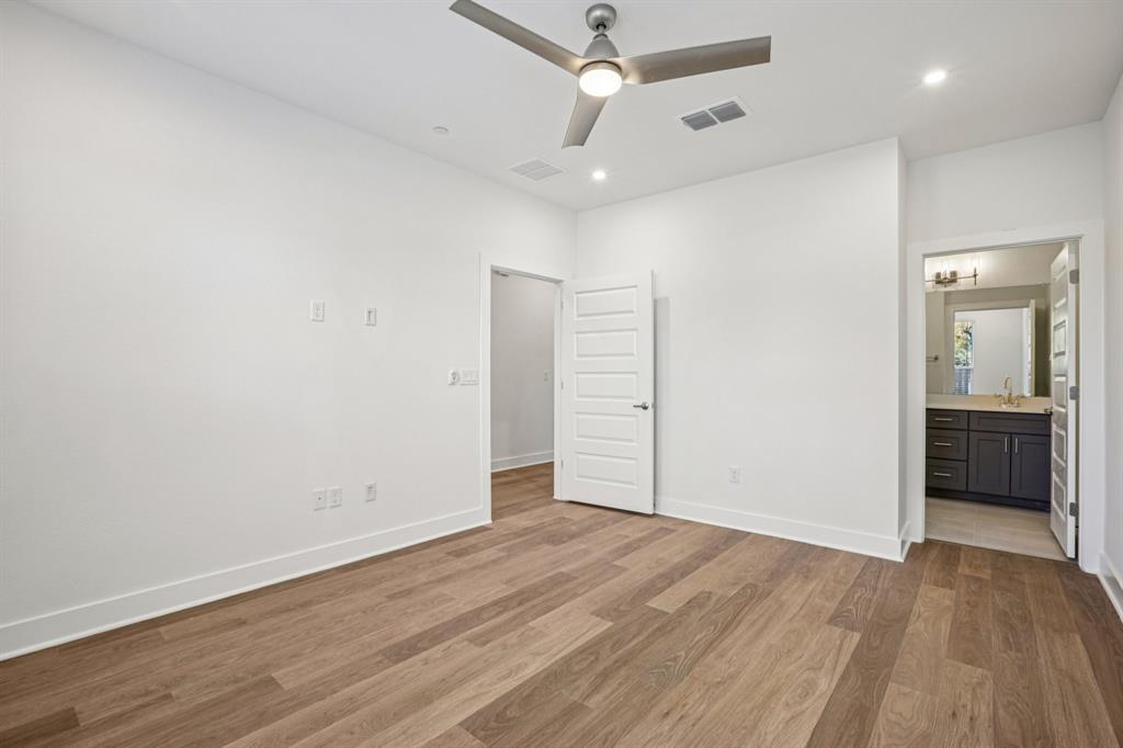 200 West 56th Street, Unit 8103 Austin, TX 78751 - Photo 10 of 13 an empty room with wooden floor and ceiling fan