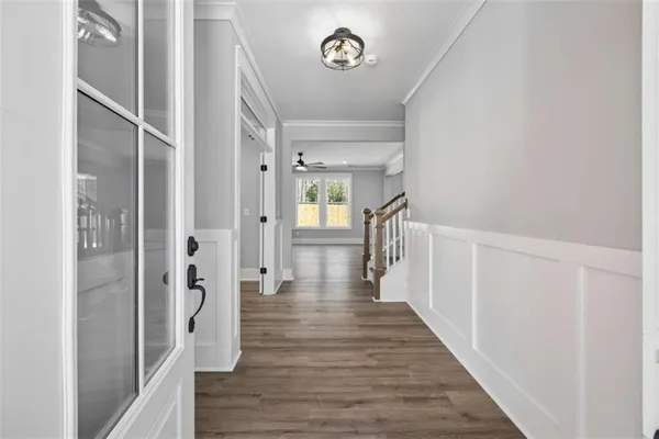 a kitchen with stainless steel appliances granite countertop a refrigerator a sink dishwasher a stove and white countertops with wooden floor