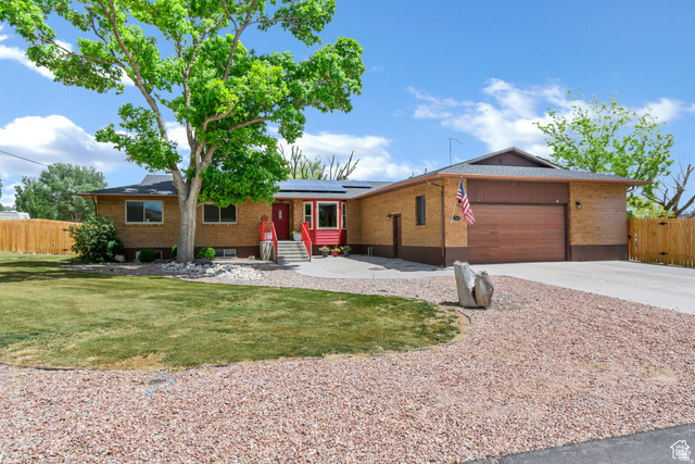 155 South 200th West Gunnison, UT 84634 - Photo 1 of 1 Ranch-style house featuring brick siding, an attached garage, solar panels, and concrete driveway