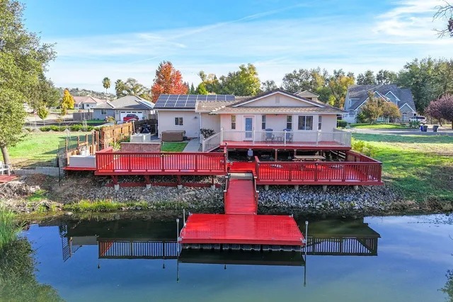 an aerial view of a house with pool and chairs