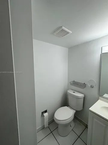 a white toilet sitting next to a white sink and vanity