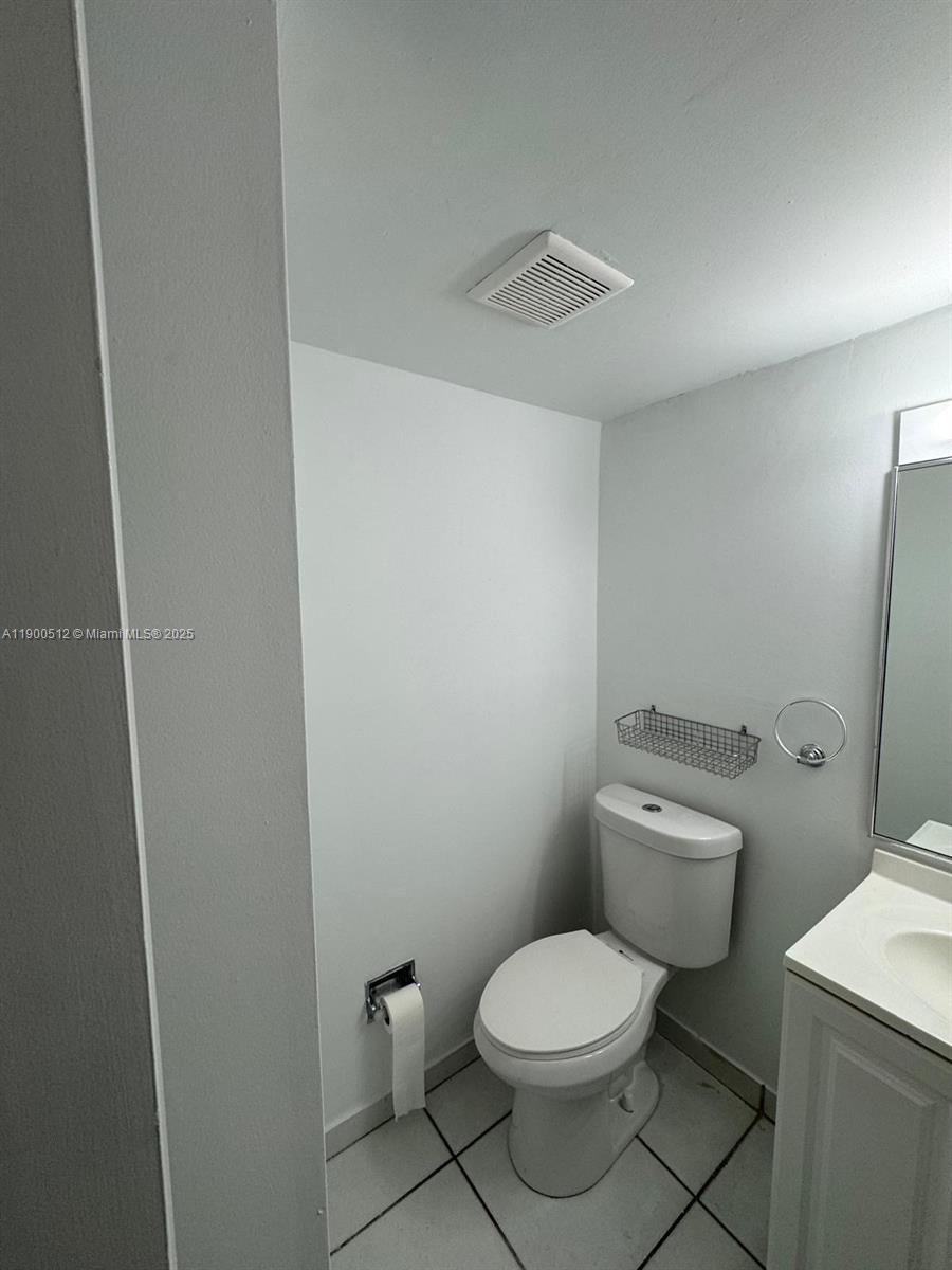9155 Fontainebleau Boulevard, Unit 5 Miami, FL 33172 - Photo 12 of 18 a white toilet sitting next to a white sink and vanity