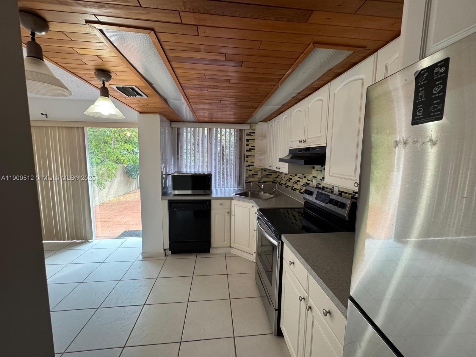 9155 Fontainebleau Boulevard, Unit 5 Miami, FL 33172 - Photo 2 of 18 a kitchen with a stove a refrigerator and a sink