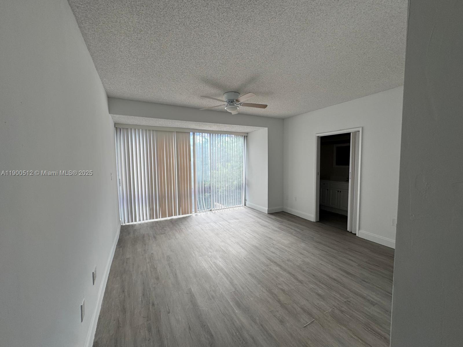 9155 Fontainebleau Boulevard, Unit 5 Miami, FL 33172 - Photo 6 of 18 a view of an empty room with a window and wooden floor