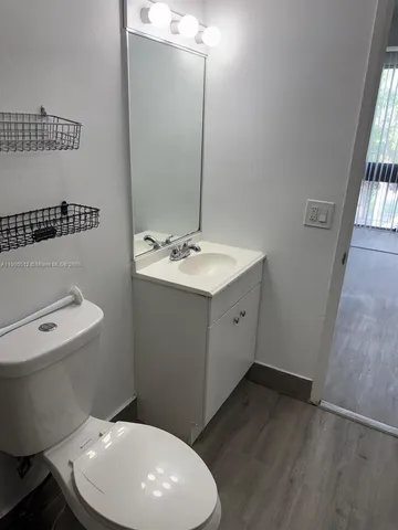 a bathroom with a toilet sink and mirror