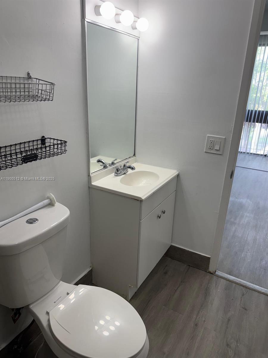 9155 Fontainebleau Boulevard, Unit 5 Miami, FL 33172 - Photo 8 of 18 a bathroom with a toilet sink and mirror