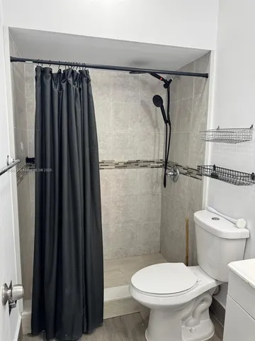 a bathroom with a toilet and a shower curtain