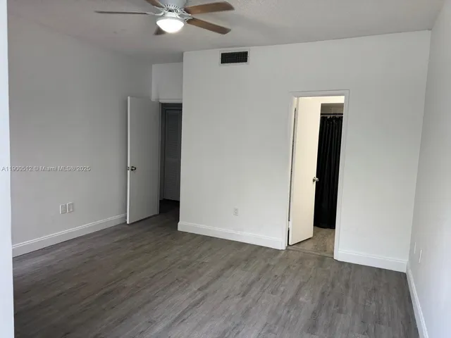 an empty room with wooden floor and closet