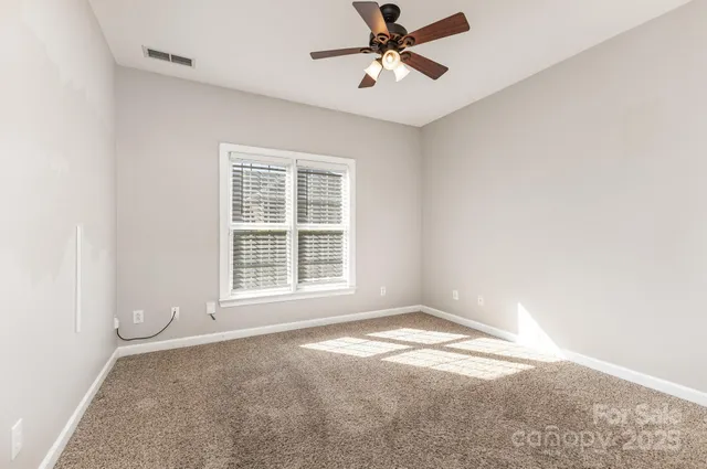 an empty room with a chandelier fan
