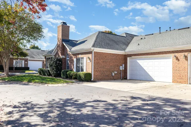 an aerial view of residential houses with outdoor space and trees