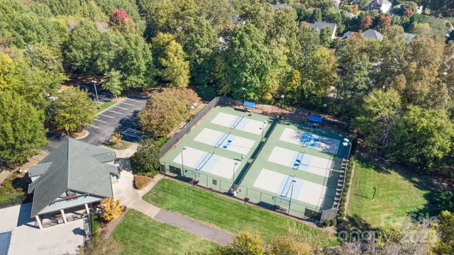 an aerial view of residential house with outdoor space and trees all around