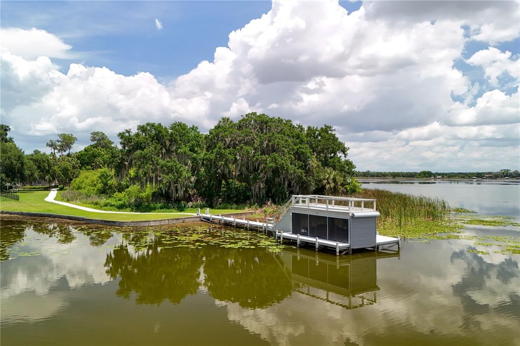 16948 Deer Island Road Tavares, FL 32778 - Photo 57 of 67 a view of a lake with a house in the background