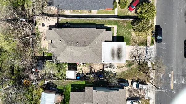 a aerial view of a house with a yard and large trees