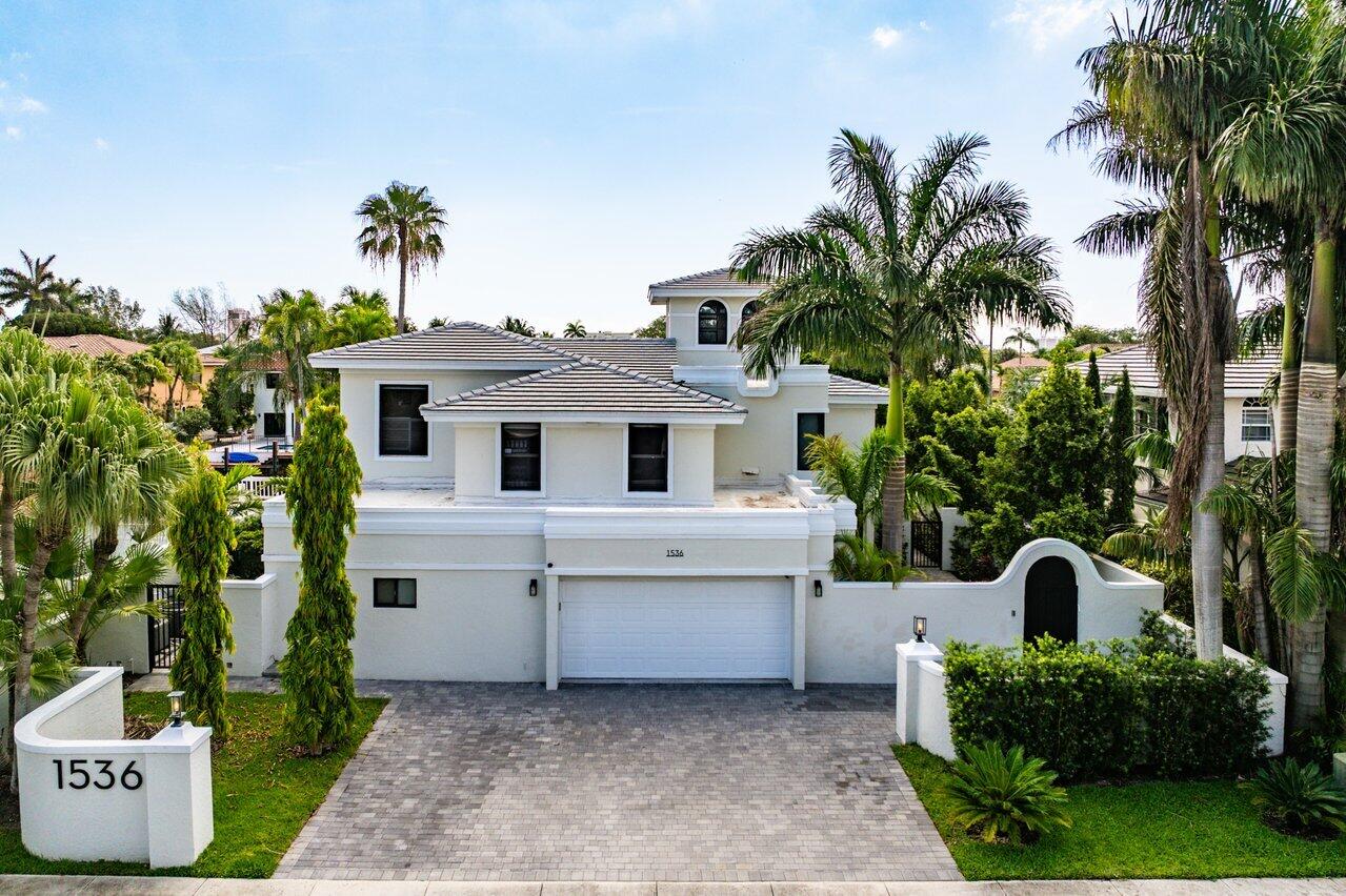 1536 Southwest 5th Avenue Boca Raton, FL 33432 - Photo 1 of 37 a view of a white house with a yard and potted plants