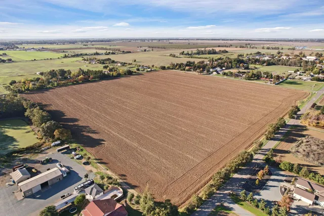 an aerial view of ocean and residential houses with outdoor space
