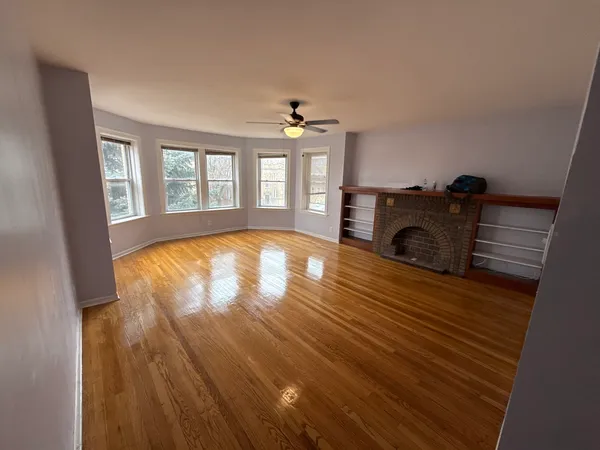 wooden floor in an empty room with a fireplace