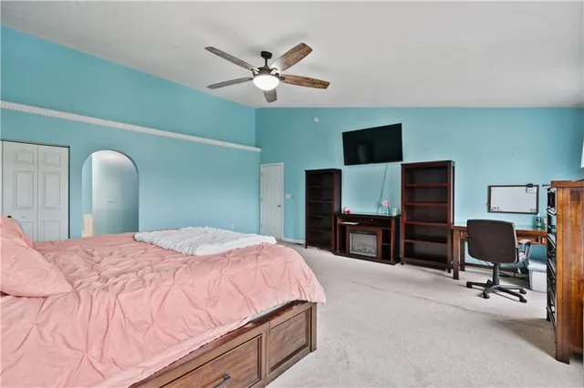 a bedroom with a bed and a flat screen tv