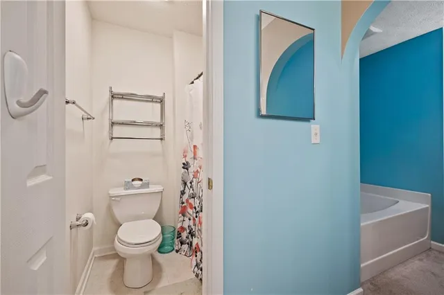 a white toilet sitting next to a bathroom sink and a shower