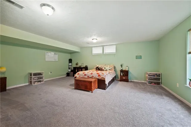 a spacious bedroom with a bed and a lamp