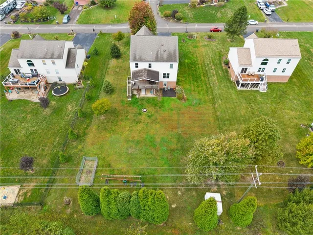 an aerial view of residential houses with outdoor space and trees