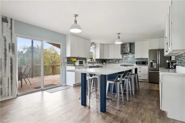 a kitchen with kitchen island a large counter top space a sink stainless steel appliances and cabinets
