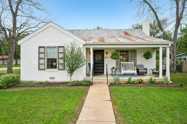 a front view of a house with a yard garden and patio
