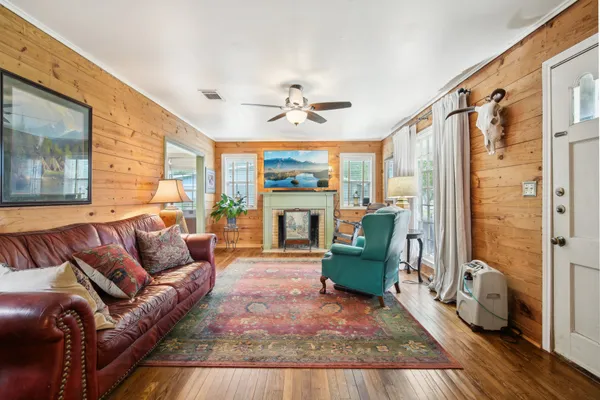 a living room with furniture a flat screen tv and kitchen view