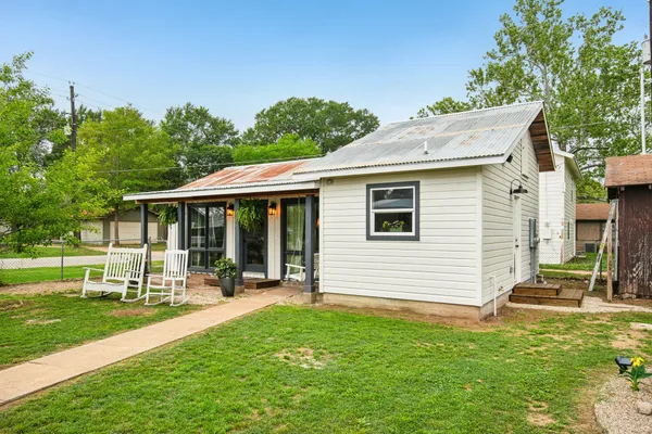 a view of a house with backyard and sitting area