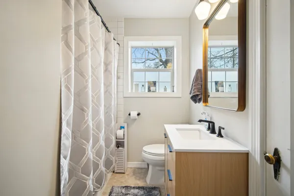 a walk in closet with a mirror and a bathroom