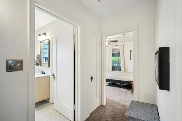 a bedroom with a bed a large window and a chandelier