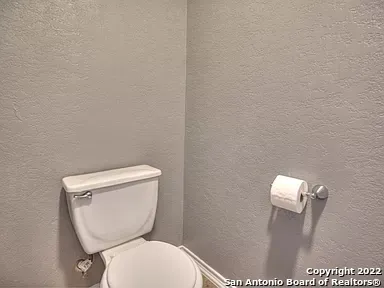 a white toilet sitting next to a wooden wall