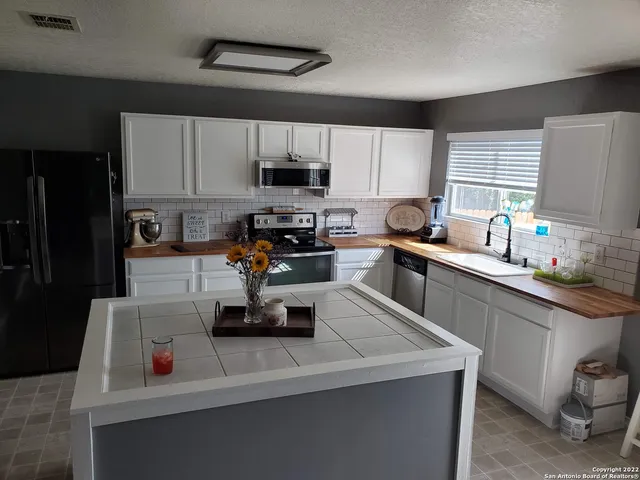 a kitchen with a sink a stove and cabinets