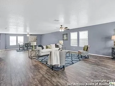 a living room with furniture a dining table and wooden floor