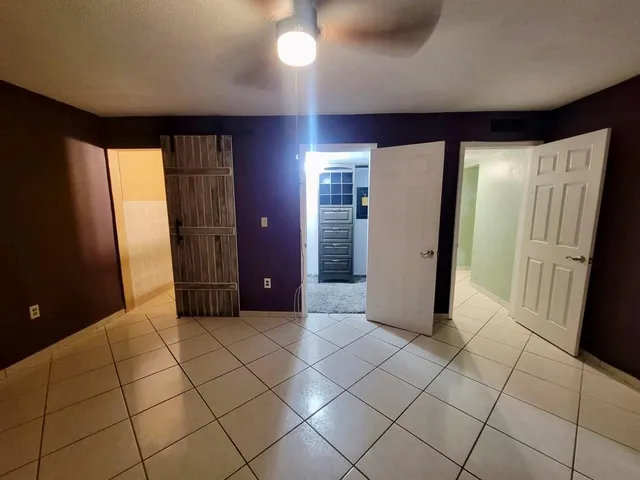 a view of a hallway with wooden cabinets