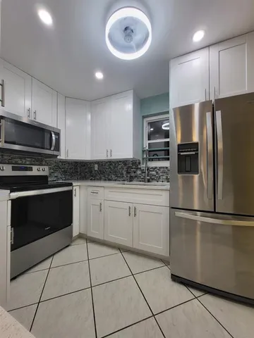 a kitchen with stainless steel appliances granite countertop a refrigerator sink and microwave