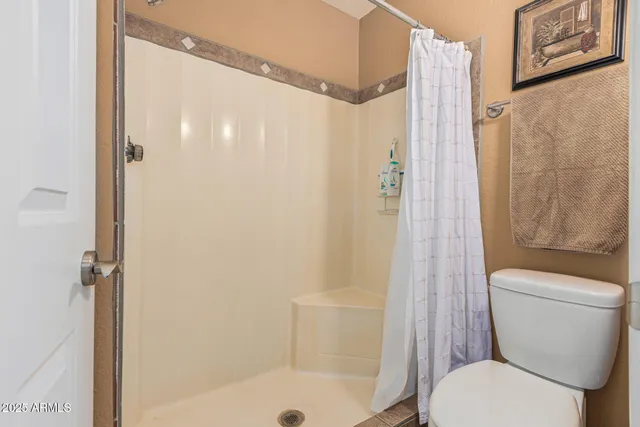 a white toilet sitting next to a bath tub